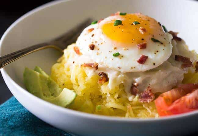Bowl of spaghetti squash with fried egg, avocado and bacon