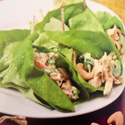 Curry chicken lettuce wraps on white plate with cashews