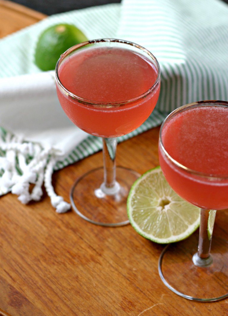 A red kombucha cosmopolitan in a glass with lime in background