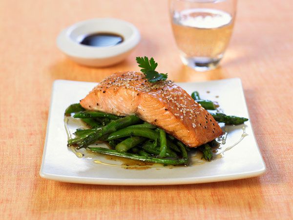 Salmon topped with chia seeds on top of asparagus
