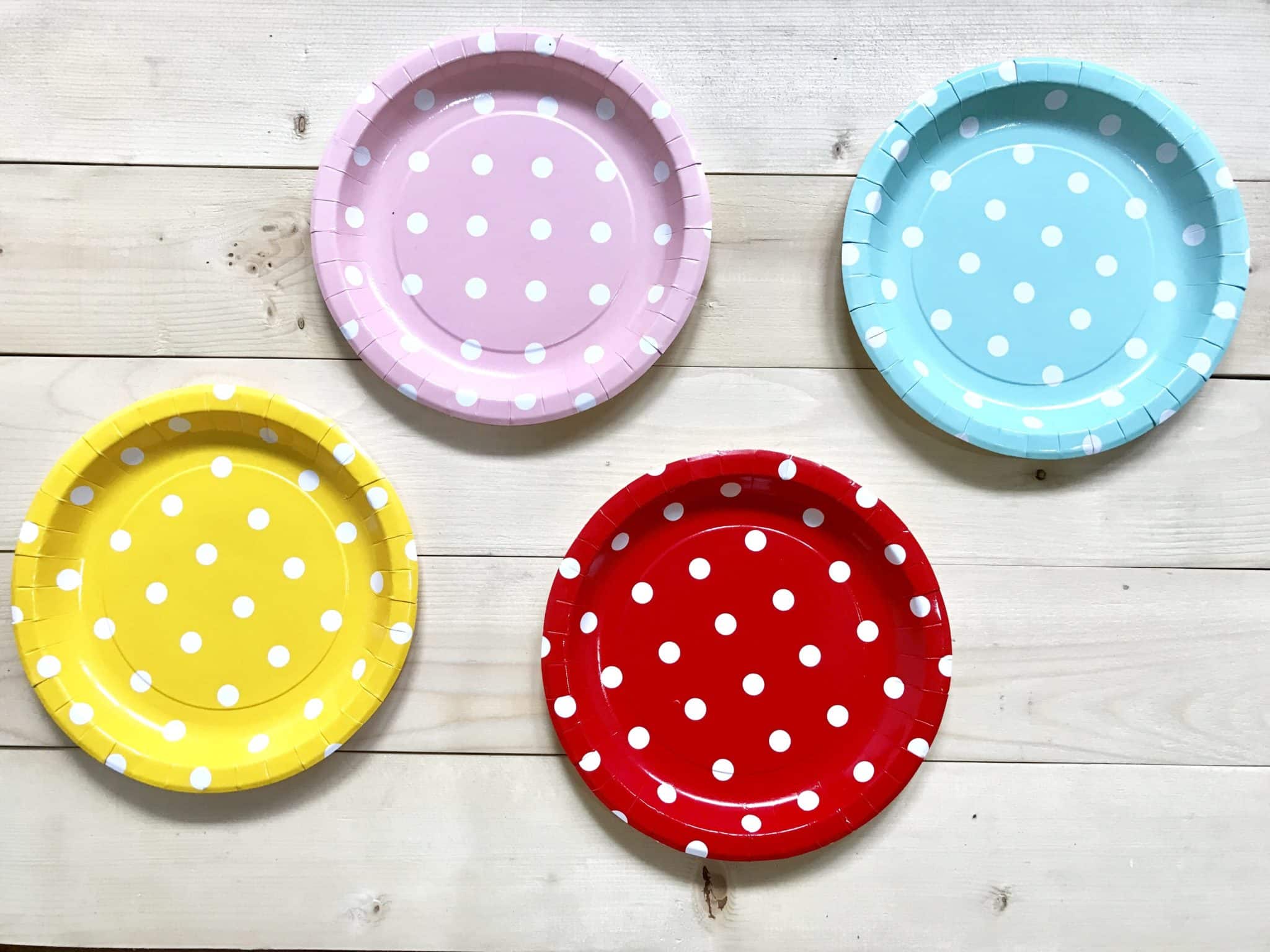 Multi-colored paper plates with polka dots on wood table