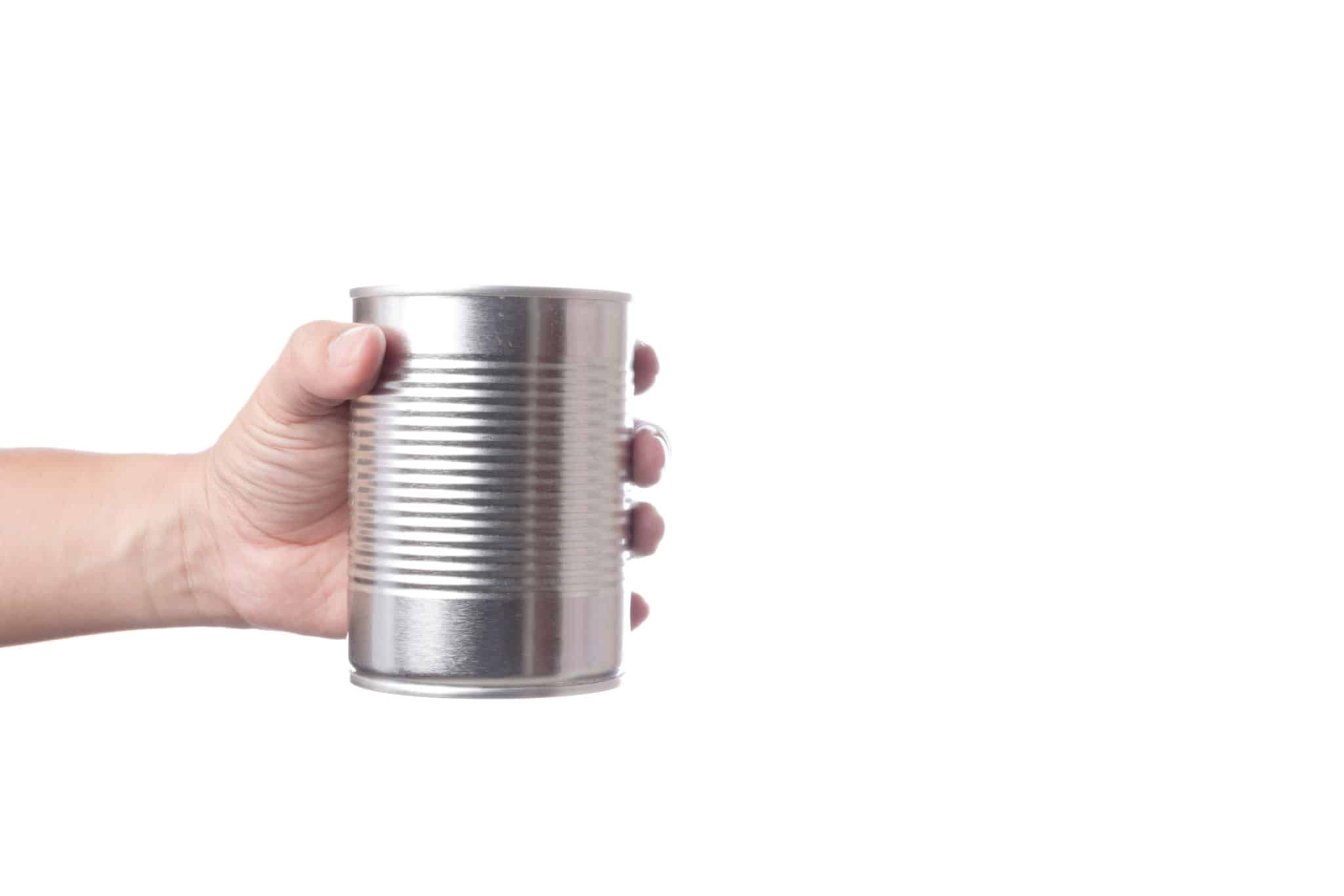 Hand holding aluminum soup can on white background