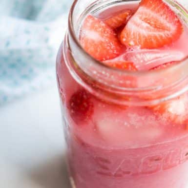 Pink drink with strawberries in a glass