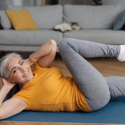 Woman doing an oblique exercise on a blue yoga mat.