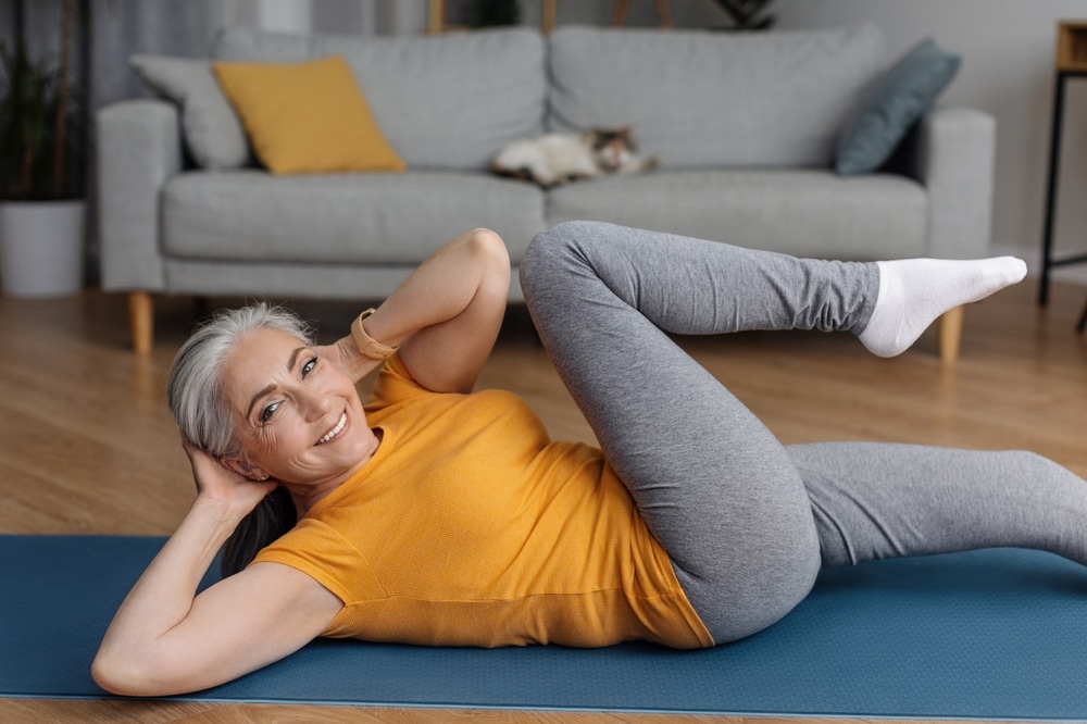 Woman doing an oblique exercise on a blue yoga mat.