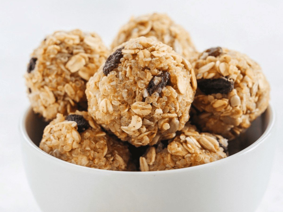 A bowl of small, round, no-bake peanut butter quinoa energy balls.