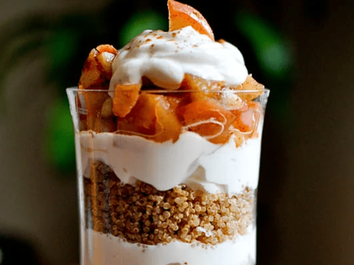 A close-up of a spiced quinoa apple pie parfait with layers of roasted apples, Greek yogurt, and quinoa.
