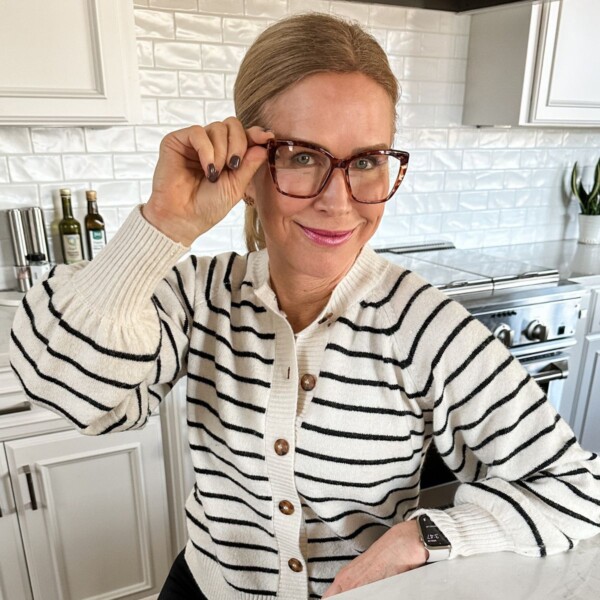 woman holding glasses smiling at camera