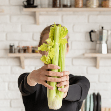 woman holding celery in her kitchen