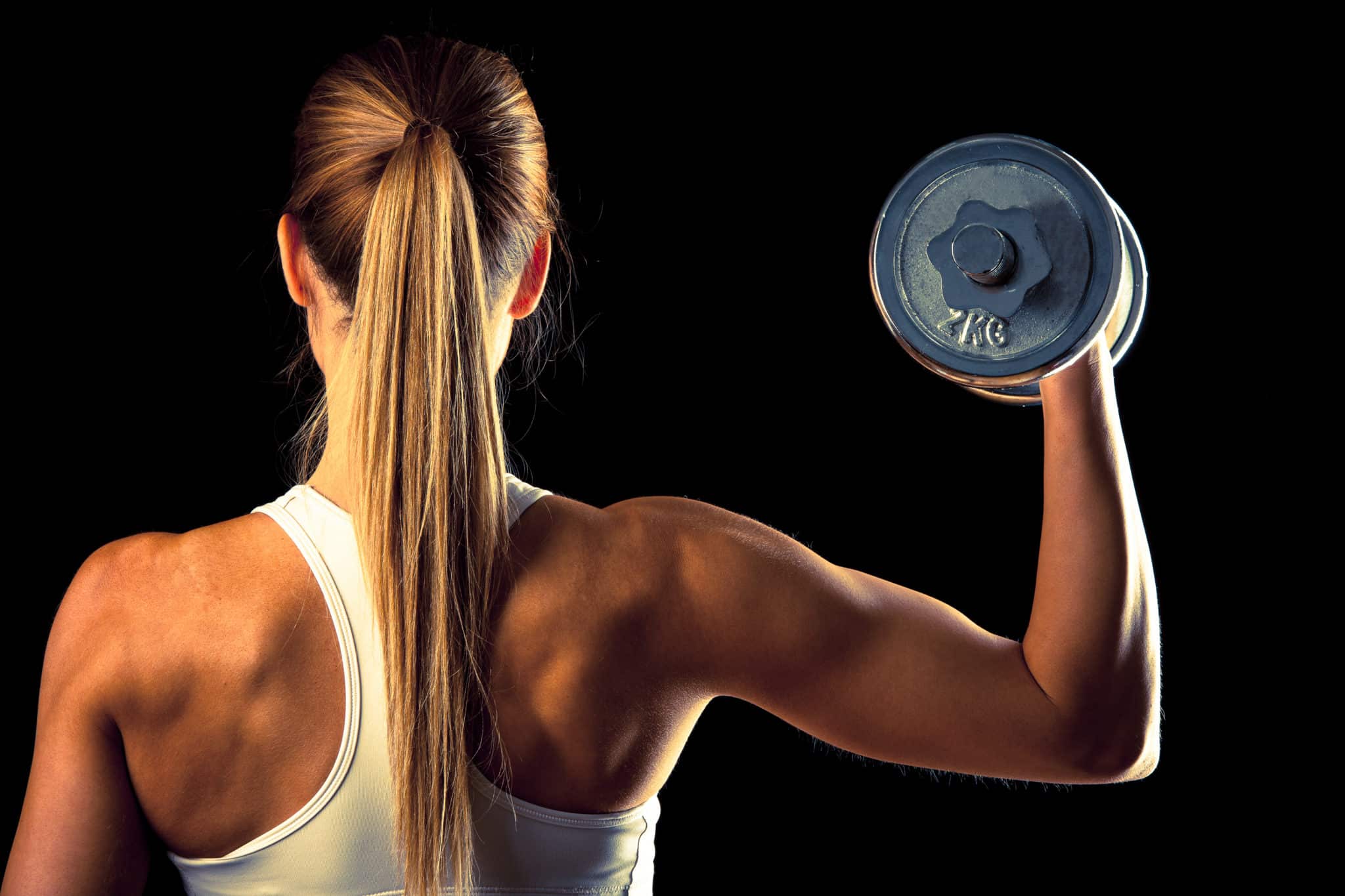 Strong woman holding up a barbell from behind
