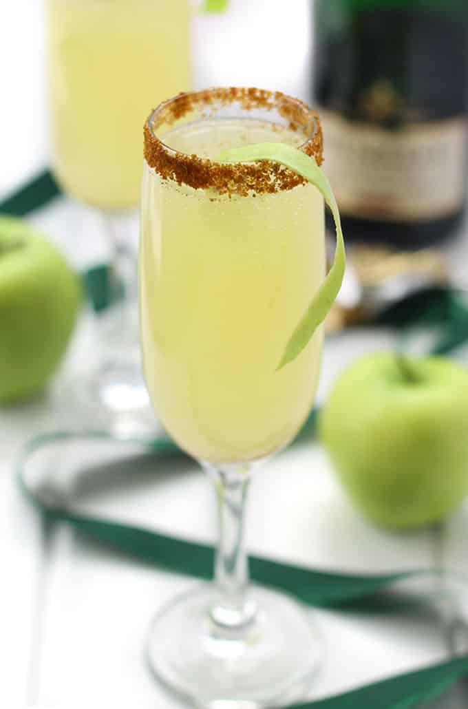 A tall flute of apple mimosa with rimmed sugar glass