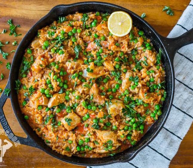 One-skillet paella in a black cast iron skillet on wood table