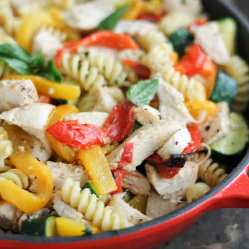 Garlic parmesan pasta with chicken and peppers in a red skillet
