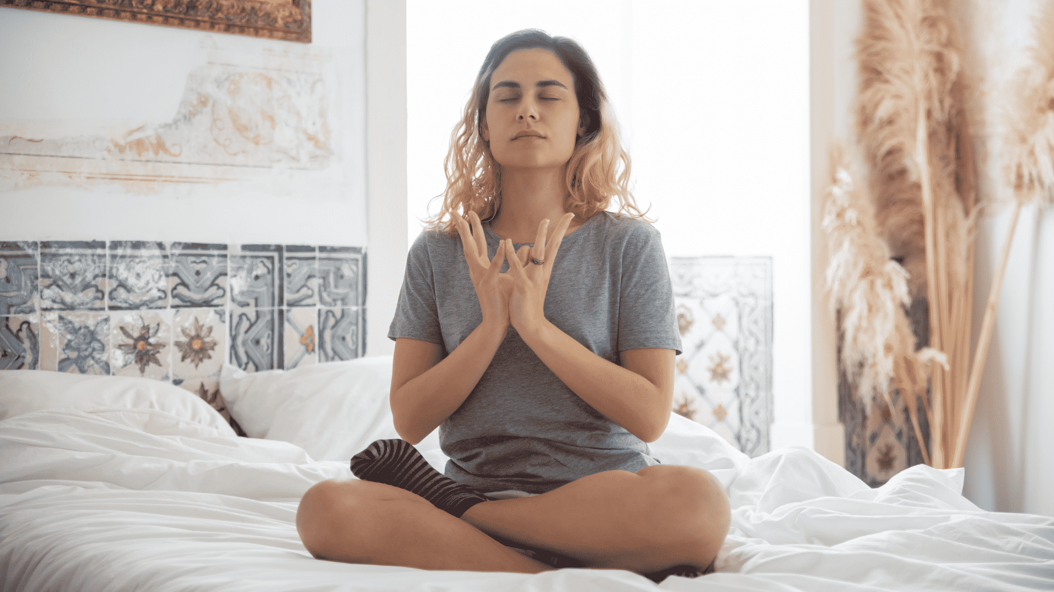 woman meditating on her bed