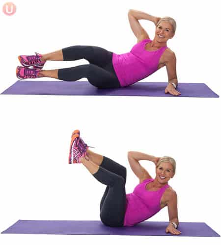 Chris Freytag demonstrating how to do oblique crunches in black leggings and pink top