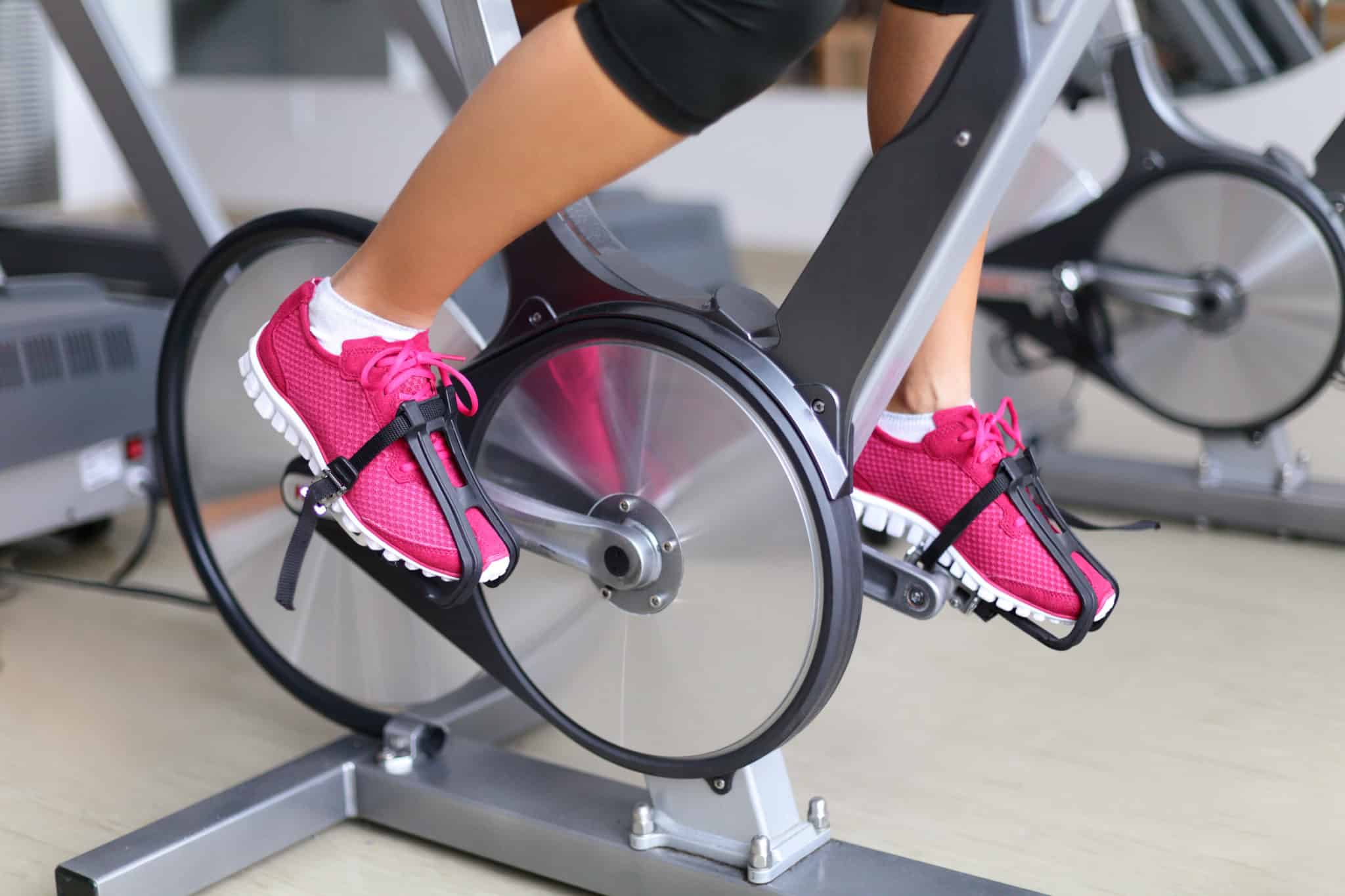 Pink tennis shoes locked into spin bike