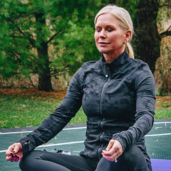 woman reducing stress through meditation outside