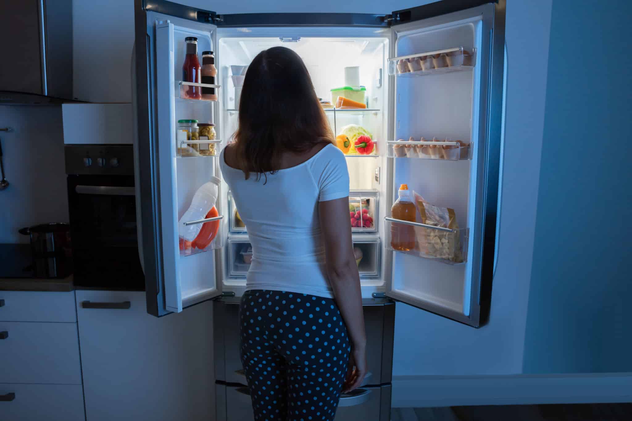 Woman standing in front of fridge