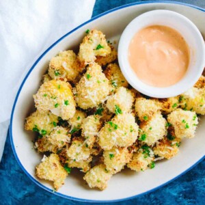 Oval dish filled with panko-crusted cauliflower and sriracha dipping sauce