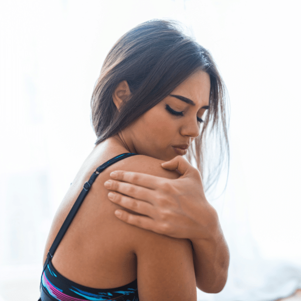 woman holding shoulder in pain