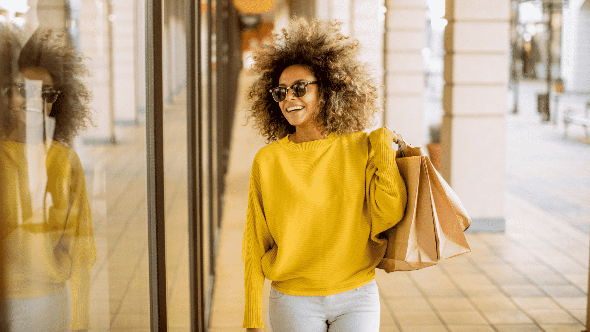 woman in yellow holding shopping bags
