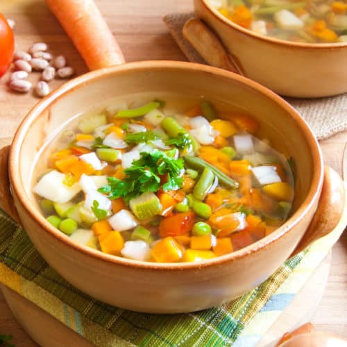 Vegetable soup with carrots, celery and more on wooden background