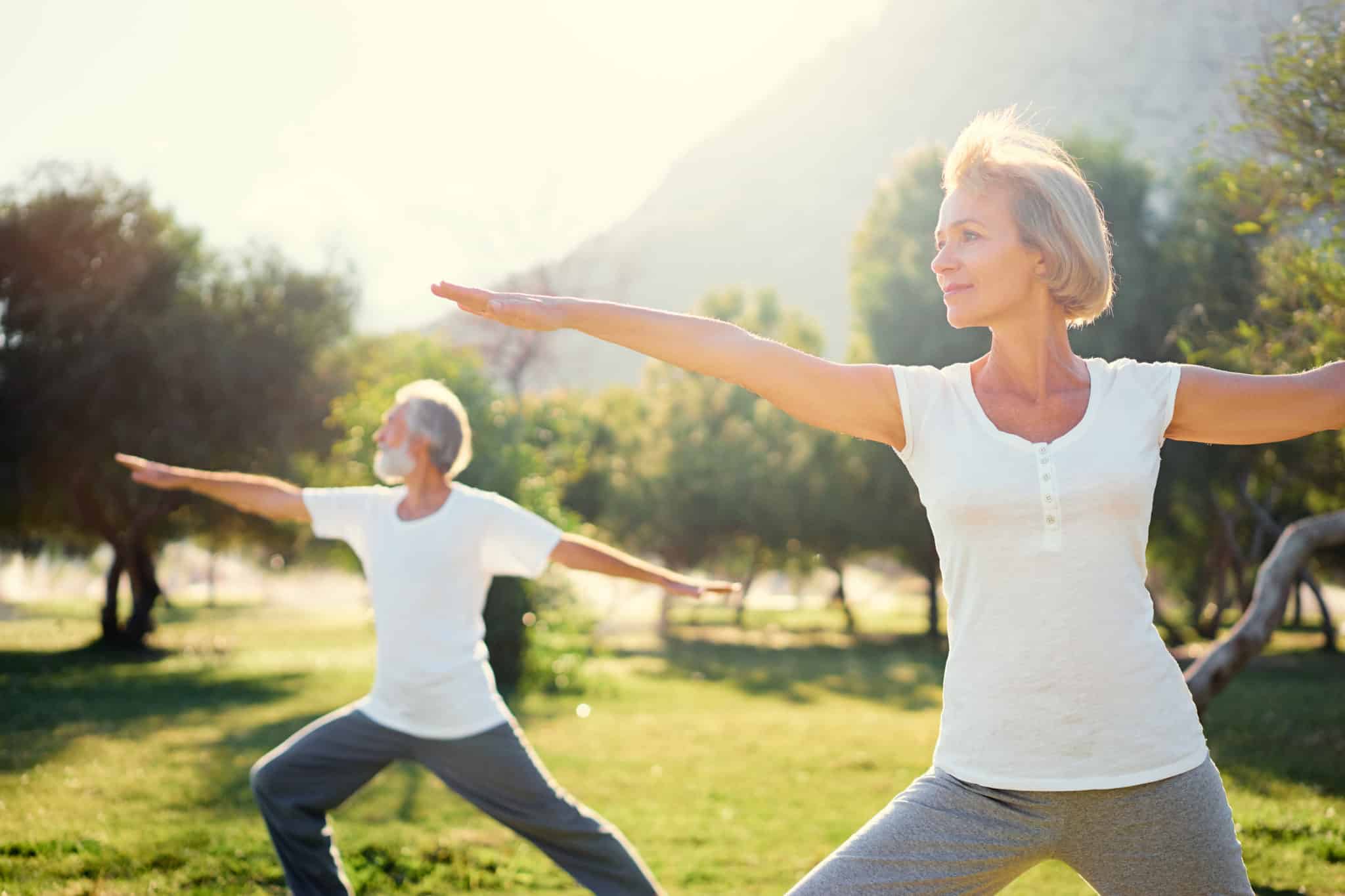 Man and woman outside practicing balance exercises for seniors