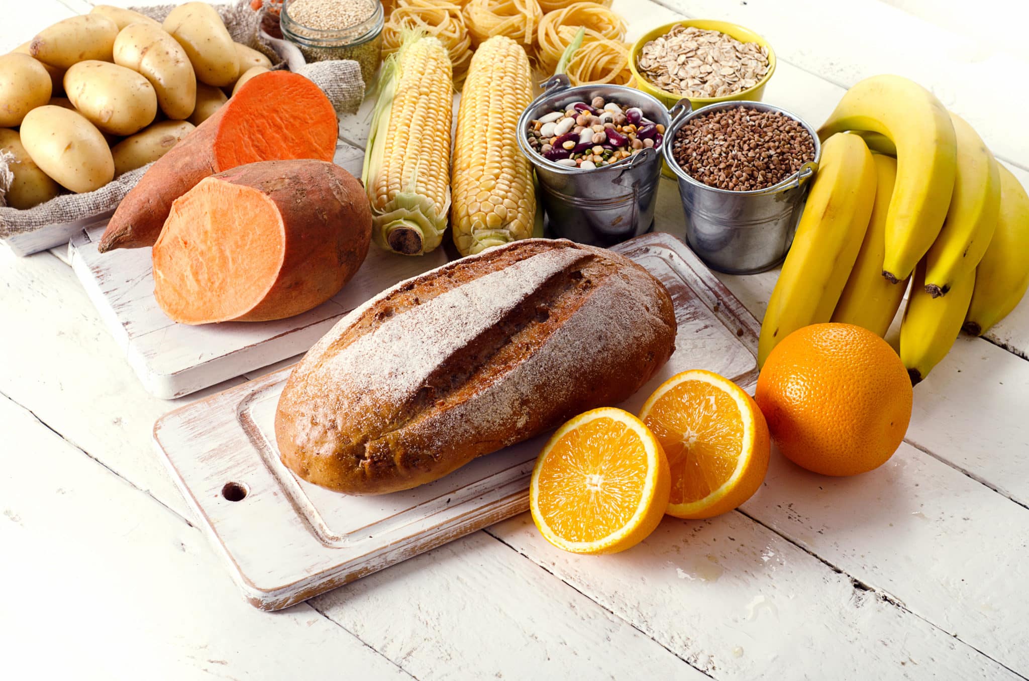 Table of various carbohydrate foods like bread, sweet potatoes, corn, and grains