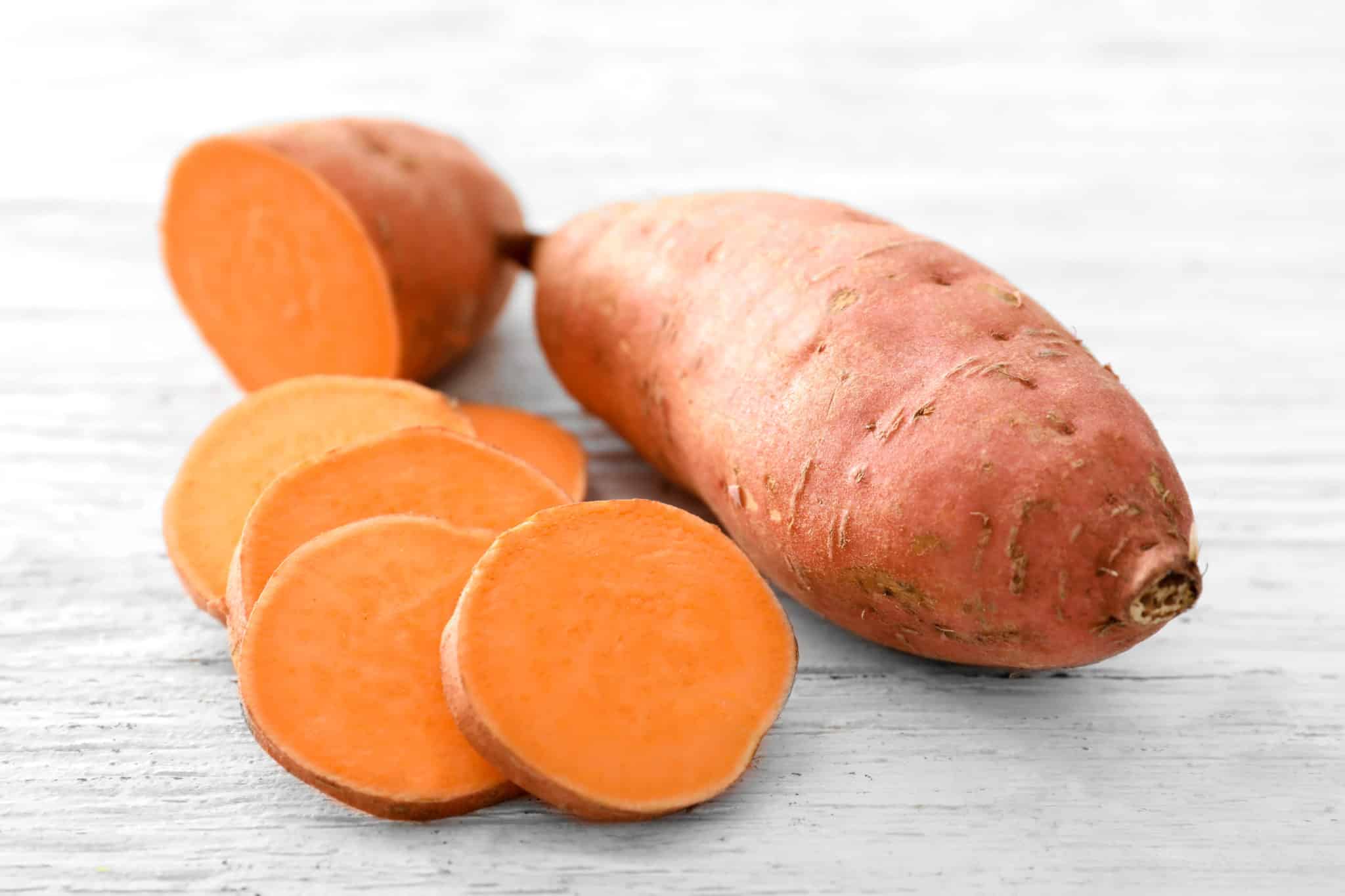 Raw sweet potato on wood table