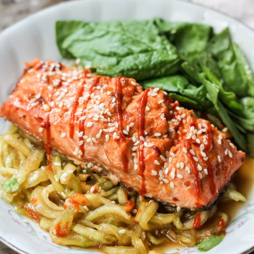 Sriracha salmon with cucumber noodles on white plate
