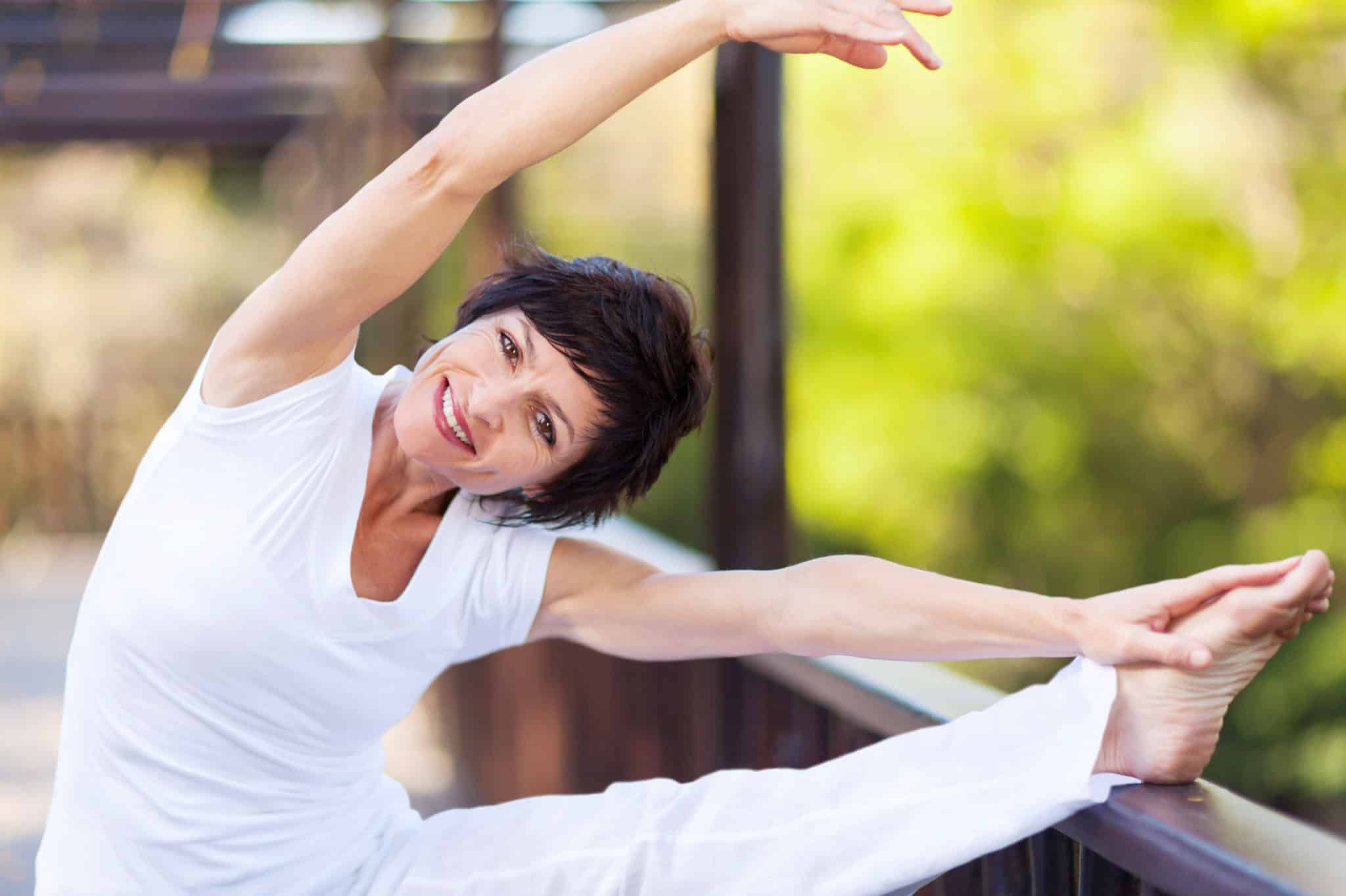 Middle aged, happy woman doing full body stretch