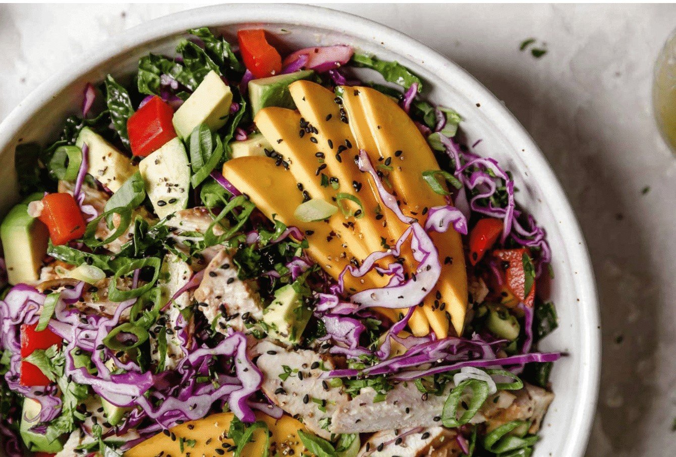 white bowl with veggies and mango