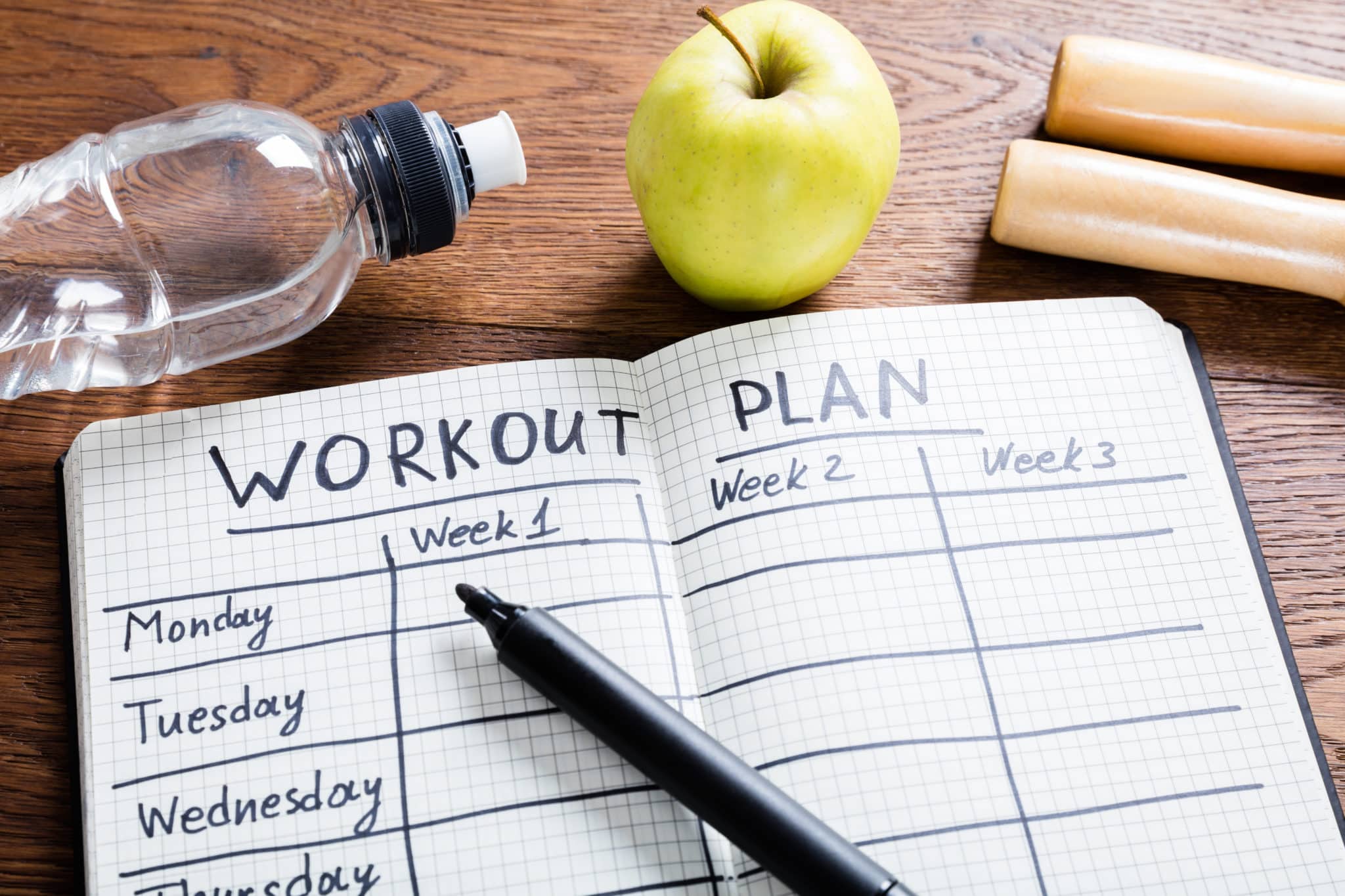 Notebook on table with text: Workout Plan