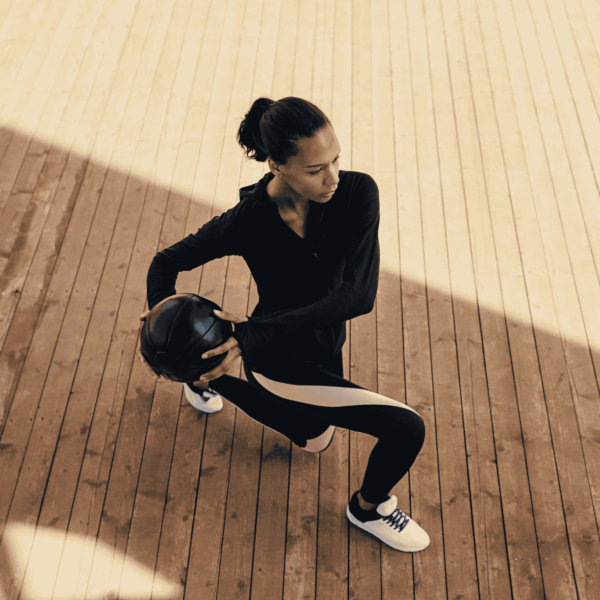 woman outside with medicine ball doing a walking lunge