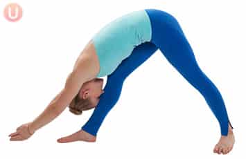Girl in all blue yoga suit doing yoga pose called pyramid pose
