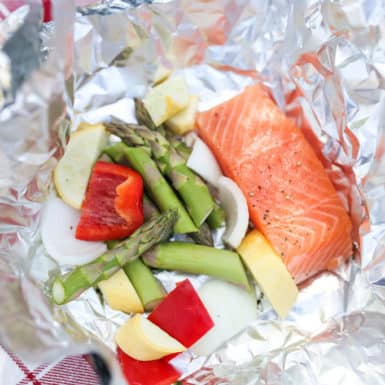 Salmon, asparagus, zucchini and peppers in a foil packet ready for grilling