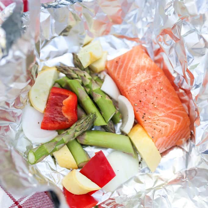 Salmon, asparagus, zucchini and peppers in a foil packet ready for grilling