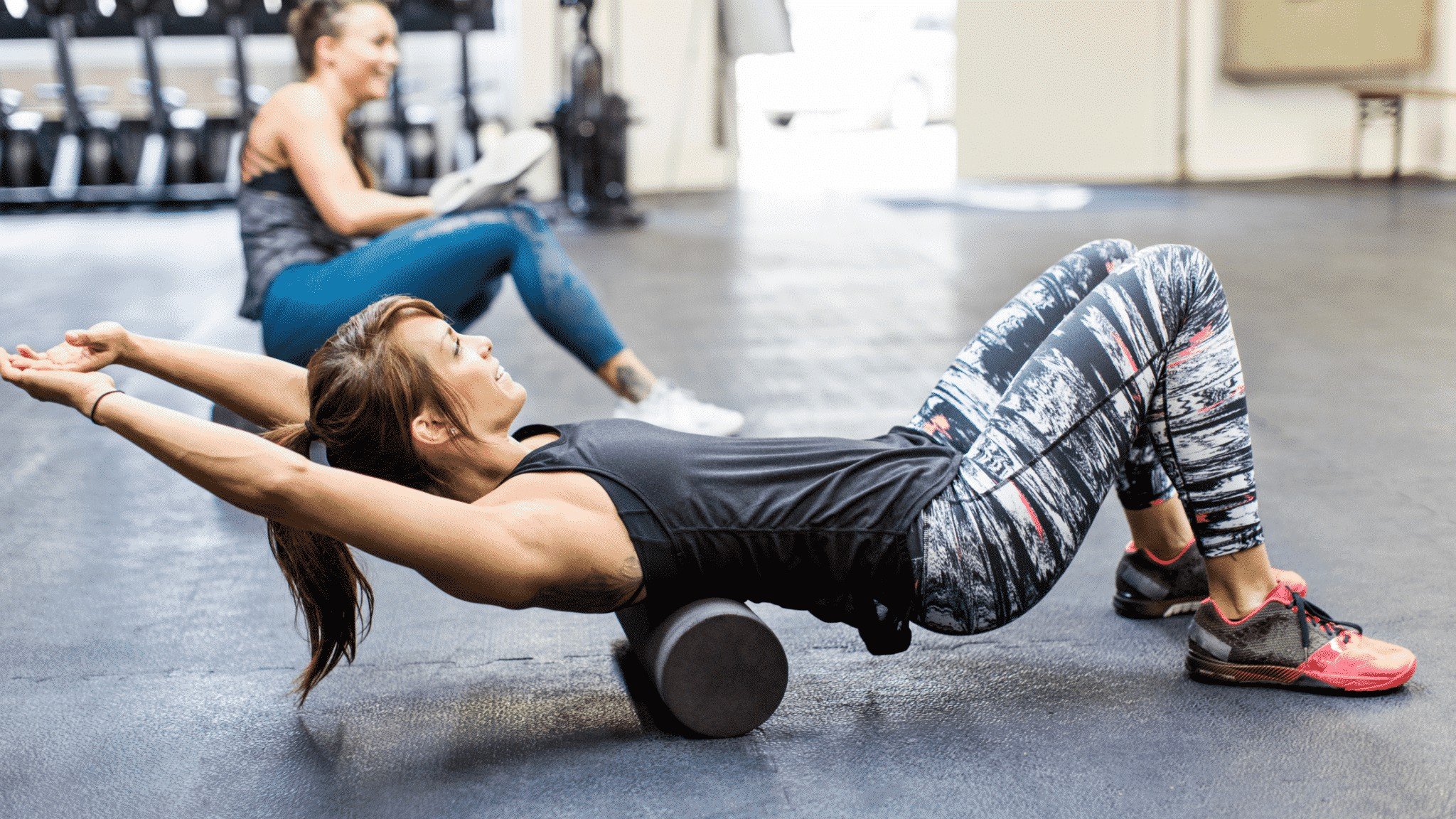 woman in gym using foam roller