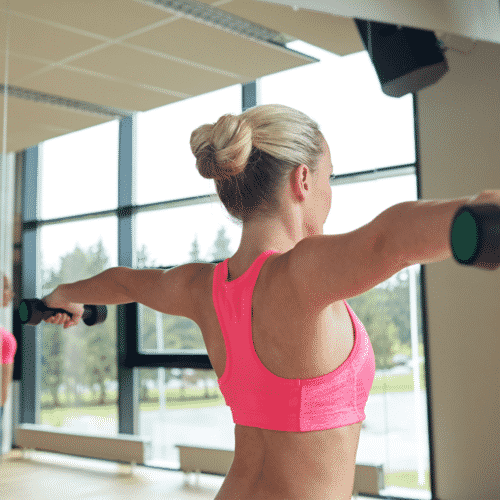 woman holding dumbbells straight out