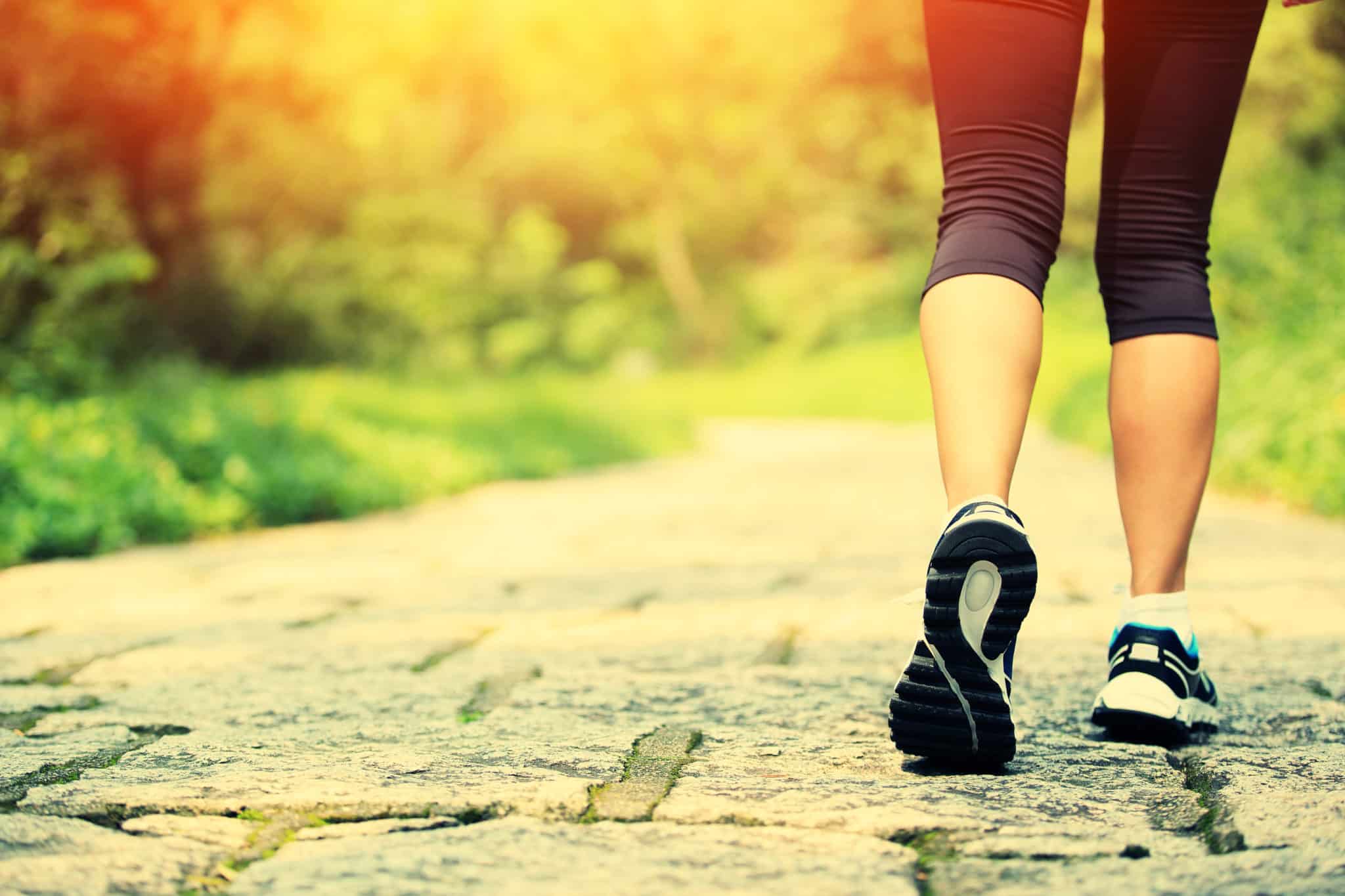 Woman walking outside with good fitness shoes for 14-day power walking challenge