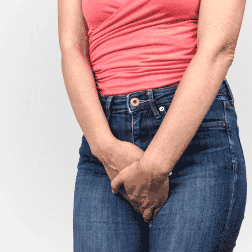 Woman crossing her legs and holding her hands to keep from peeing due to female bladder leakage