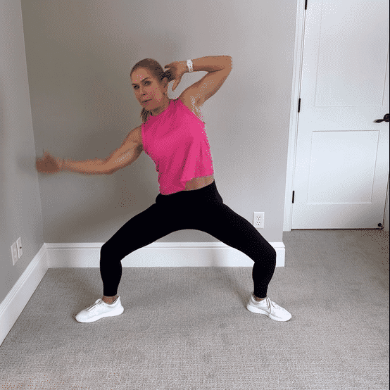 Chris Freytag wearing a pink tank top and black leggings performing oblique burners. 