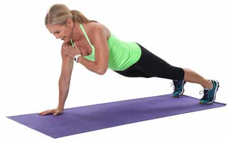Chris Freytag performing plank shoulder taps in a chest workout for women warm-up