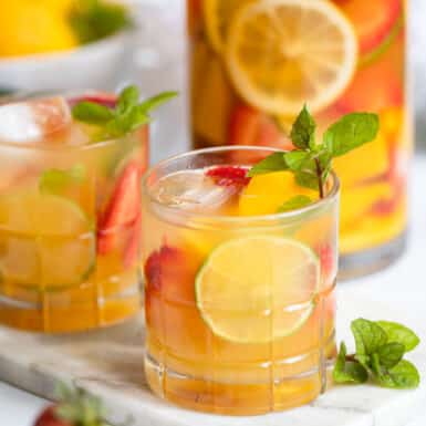 strawberry mango white wine sangria in a glass garnished with fresh mint.