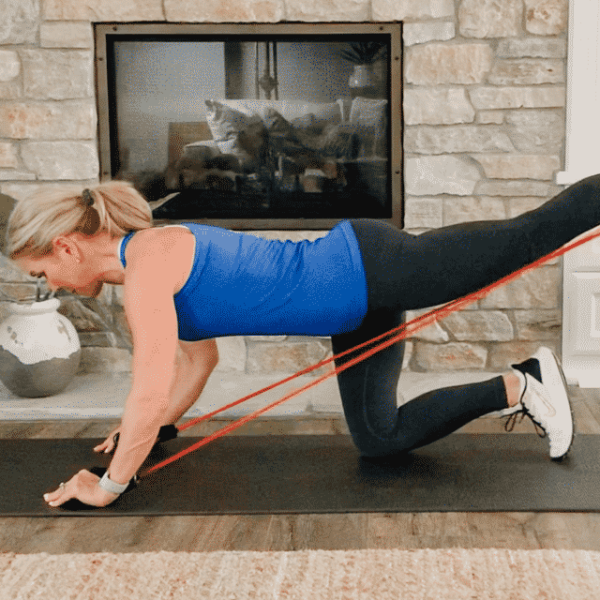 Chris Freytag holding a resistance band glute kickback.