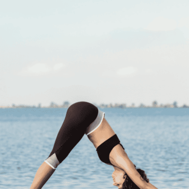 woman doing downward dog on a dock