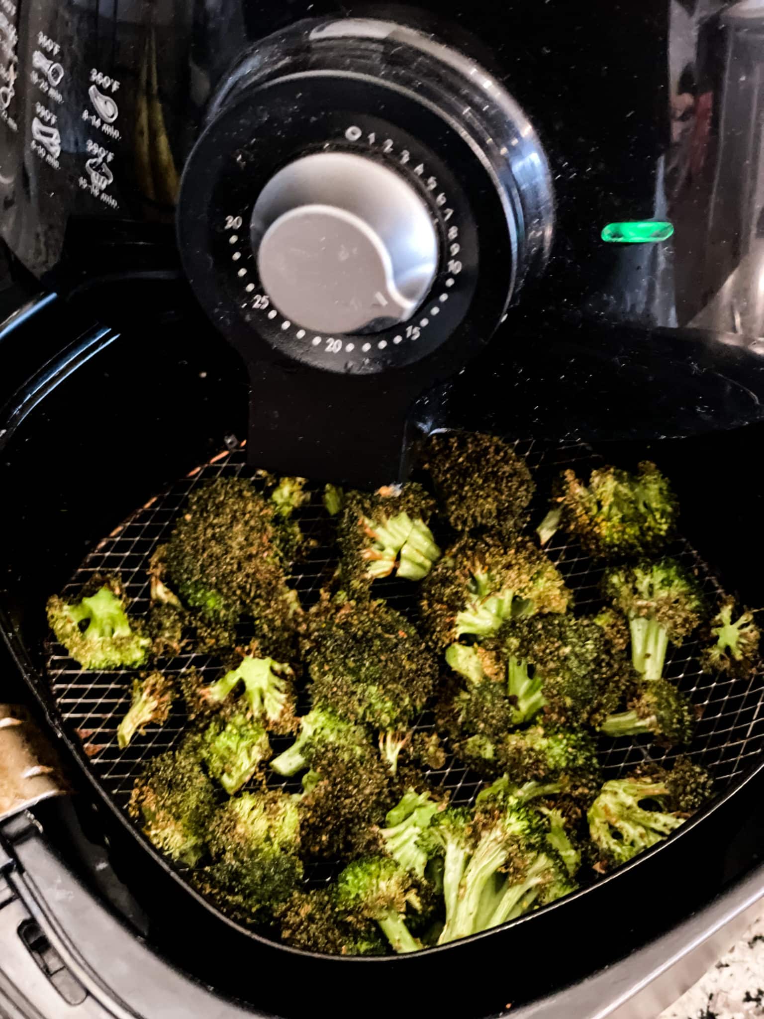 Broccoli florets in the basket of an air fryer