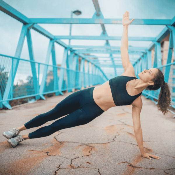 woman doing star plank on blue bridge