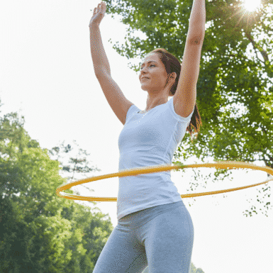 woman outside doing hula hoop workout
