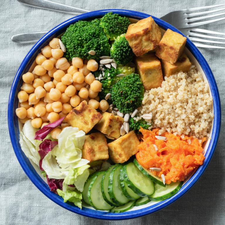 Bowl of chickpeas, cucumbers, broccoli, quinoa, tofu, and carrots